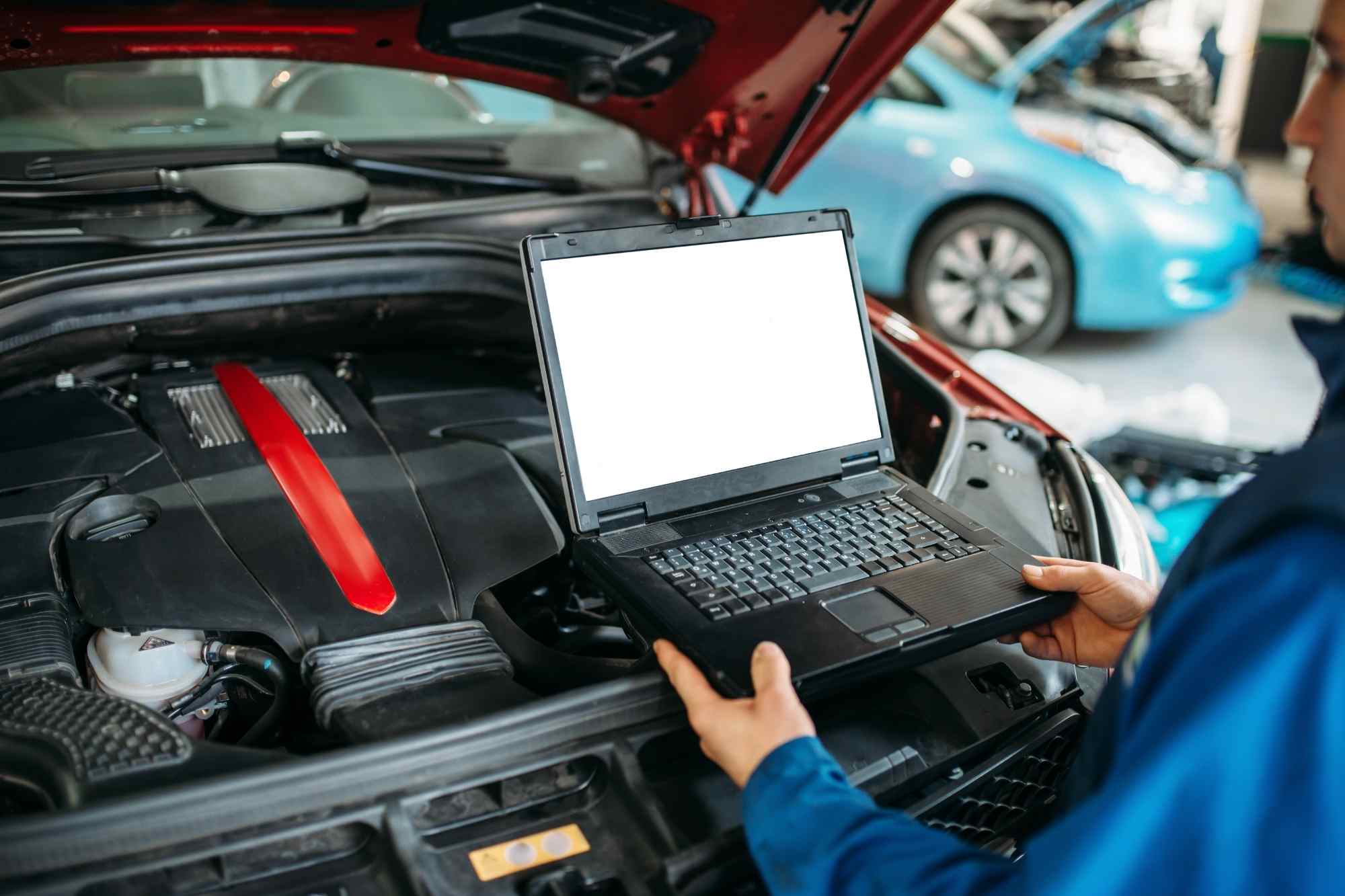 Técnico conectando escáner OBD2 para diagnosis electrónica avanzada en vehículo